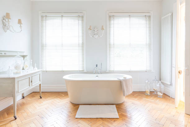 Salle de bain lumineuse avec beignoire et parquet