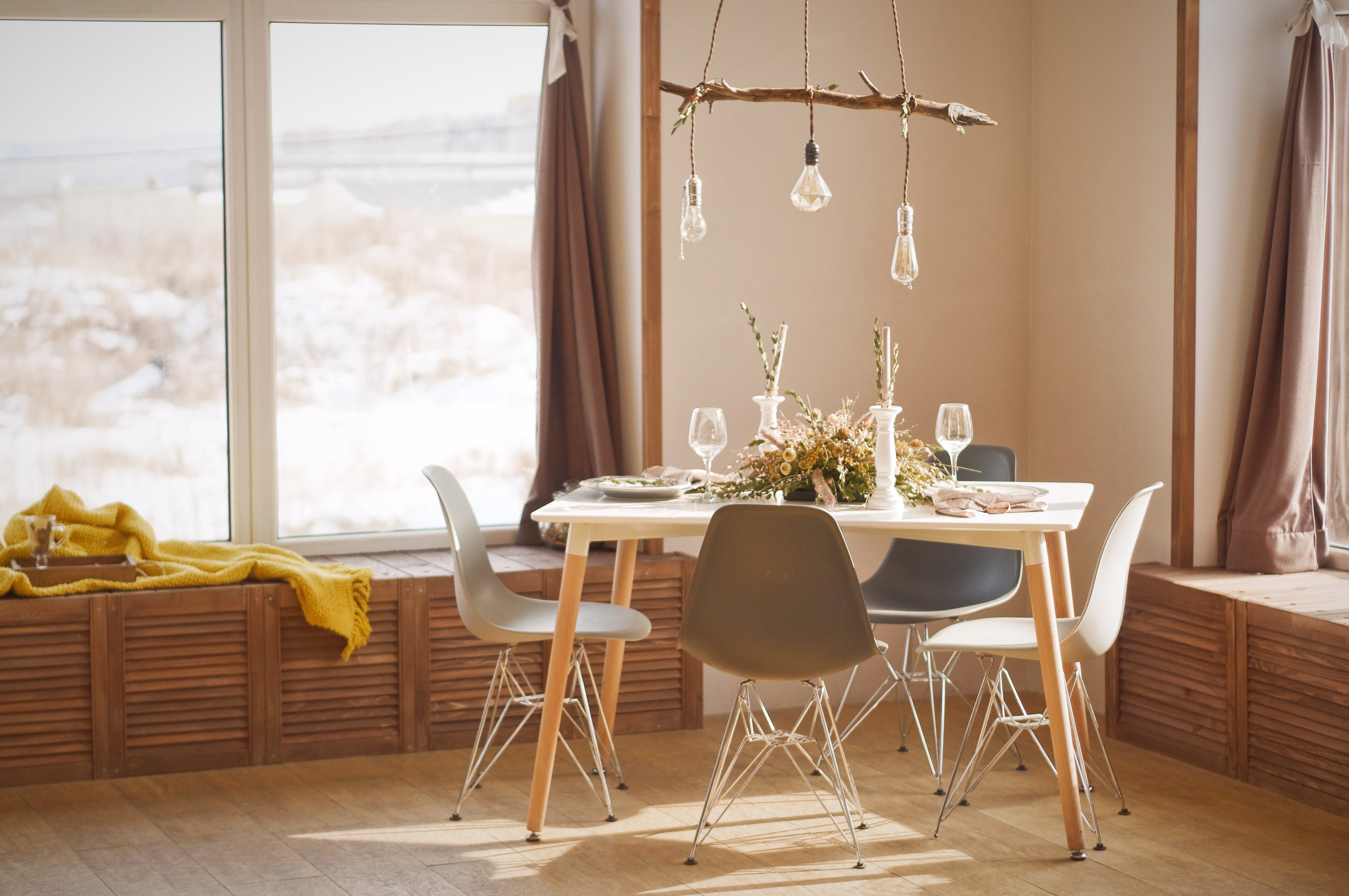 Petite salle à manger aux couleurs terreuses et un lustre en bois